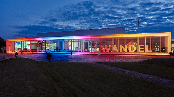 Die Lichtinstallation Frame am Erweiterungsgebäude leuchtet in Regenbogenfarben.