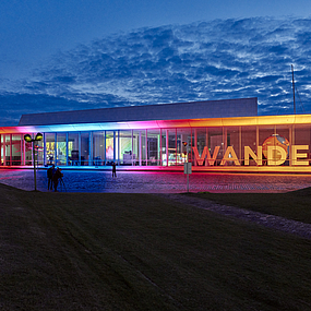 Die Lichtinstallation Frame am Erweiterungsgebäude leuchtet in Regenbogenfarben.