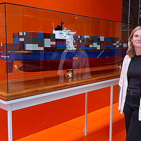 Renée Hoogland vor dem Modell eines Containerschiffs