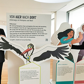 Stüve und Schemkes stehen vor den Aufstellern der Ausstellung