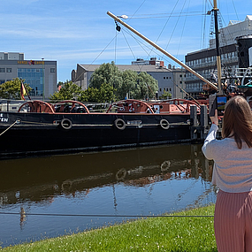 Frau vor einem Schiff