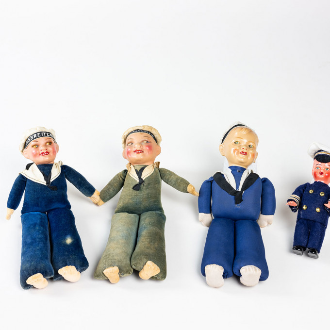 Doll in blue uniform with inscribed sailor cap "MS BREITENSTEIN".